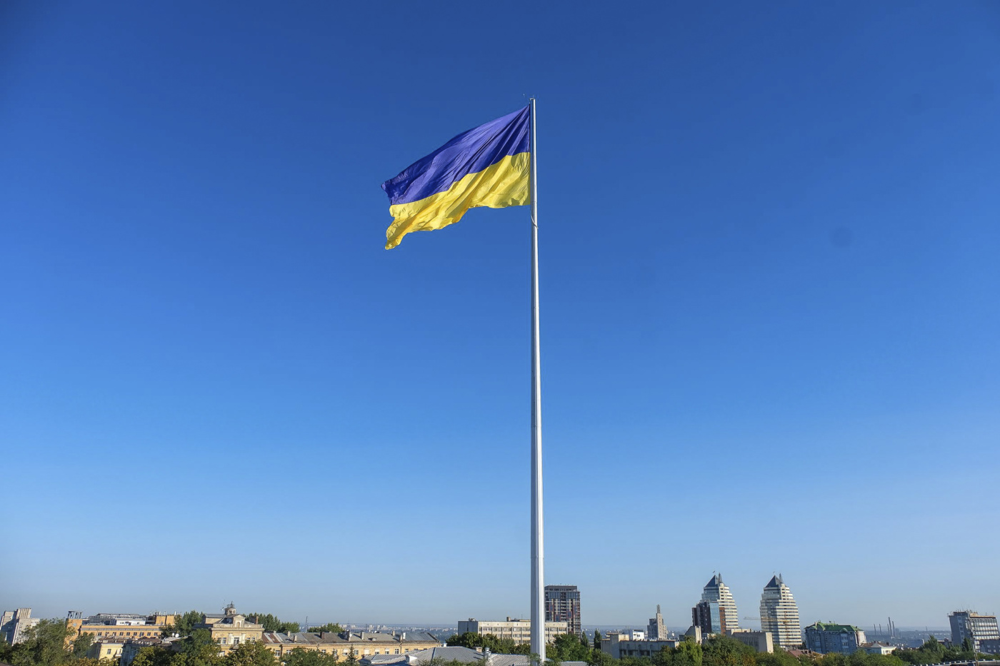 Ukrainische Flagge auf Fahnenmast über der Stadt Dnipro